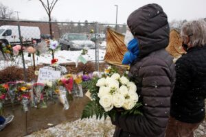 People leave flowers at the site of a mass shooting in Boulder. March 23, 2021.