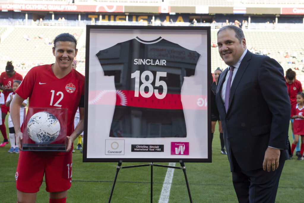 Christine Sinclair is presented with the game ball and a commemorative jersey for breaking the world's all-time international goalscoring record