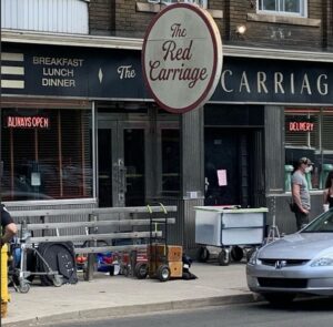 A film shoot takes place outside The Lakeview, renaming it "The Red Carriage" for production.