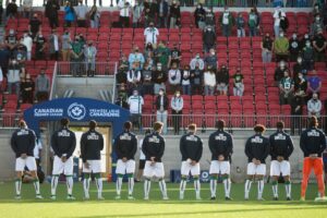 Players from York United FC stand during the national anthem ahead of their match against Forge FC, at York Lions Stadium in July 2021.