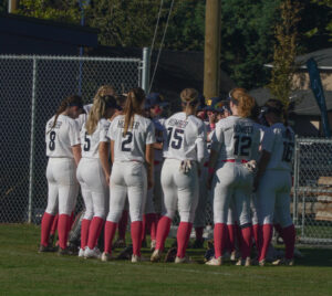 Humber Softball players in a circle talking to each other.