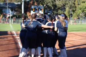 Humber Softball players hugging each other and celebrating after winning the bronze match.